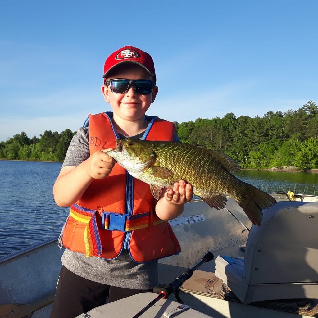 Young boy holding a French River Smallmouth Bass
