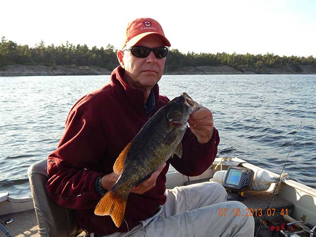 Man fall fishing and holding a 28 inch French River Walleye