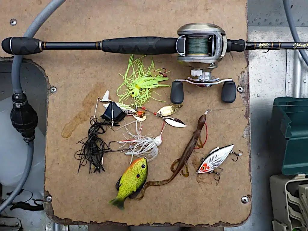 Low profile bass baitcasting rod & reel combo with an assortment of bass lures.