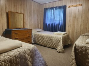 Bear Cub Cottage Room 2 with 3 single beds and a Wooden Dresser